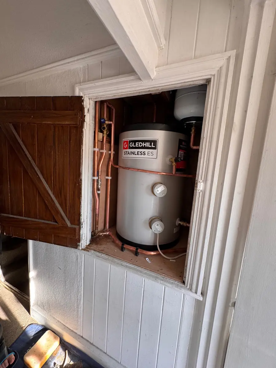 Hot water cylinder installation in a fitted cupboard